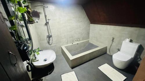 a bathroom with a tub and a toilet and a sink at Sigiri Veenus Tree House in Sigiriya