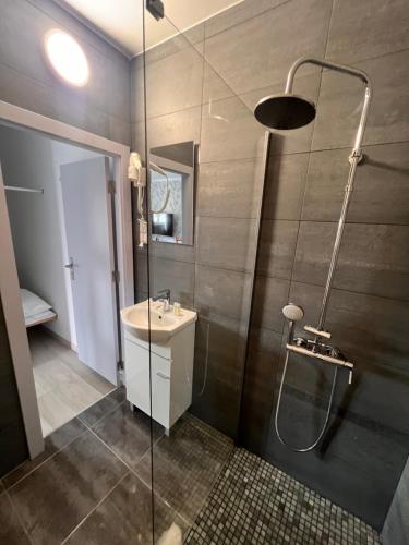 a bathroom with a glass shower and a sink at White Guest in Fátima