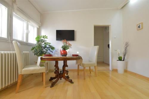 a dining room with a table and chairs and a tv at Downtown dell Arte in Novi Sad