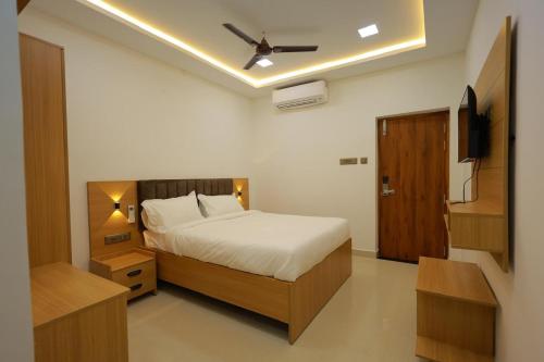 a bedroom with a bed and a ceiling fan at ChanTini Inn in Velankanni