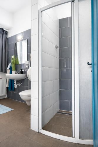 a bathroom with a shower and a toilet and a sink at WOW City Hostel in Budapest