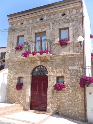 a building with a red door and purple flowers at La Casa Del Palombaro in Ortona