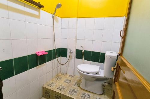 a bathroom with a toilet and a shower at Hotel Pattimura powered by Cocotel in Stasiun Tawang