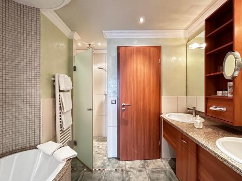 ein Badezimmer mit Badewanne, Waschbecken und Dusche in der Unterkunft Hotel Im Engel in Warendorf
