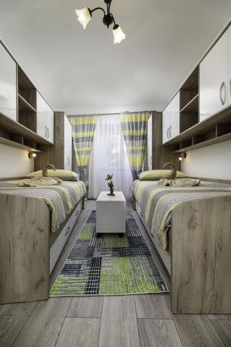 two beds in a room with wooden floors at Apartment Jelusic in Baška