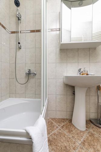 a bathroom with a tub and a sink and a shower at Apartment Jelusic in Baška
