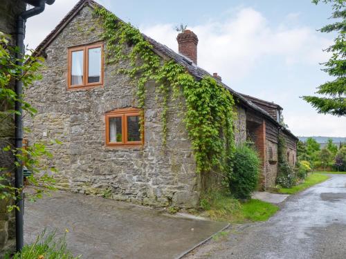 an old stone house with ivy growing on it at Lower Barn in Wistanstow