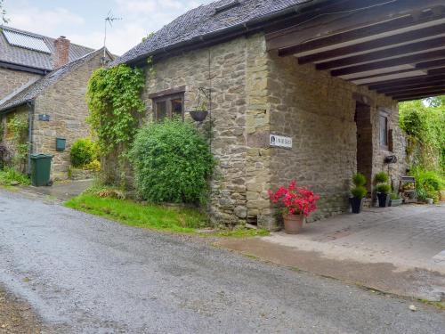 a stone building with plants on the side of it at Lower Barn in Wistanstow