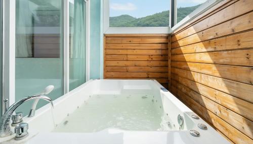 a bath tub in a bathroom with a window at Gapyeong Areuno Pet Pension in Gapyeong