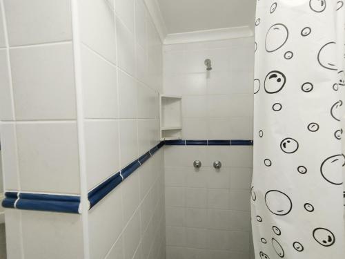 a bathroom with a shower with a shower curtain at Boathouse Bed and Biscuit - Cabin in Margate
