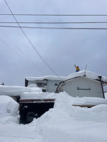 a pile of snow on top of a house at PEUF Lodge in Otari