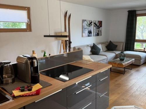 a kitchen and a living room with a couch at Schliersee-Lounge in Schliersee