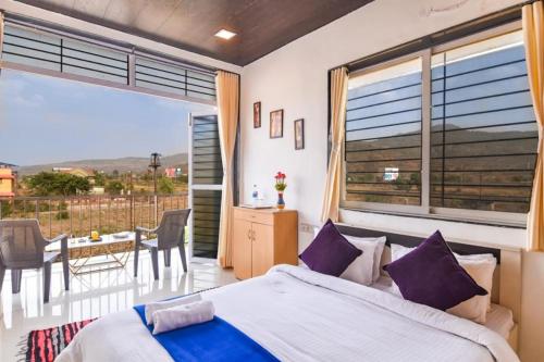 a bedroom with a bed and a balcony with a table at ll EMPYREAN STAY ll LUXE ll FORTUNE VILLA ll 4BHK ll AC ll BIG POOL in Lonavala