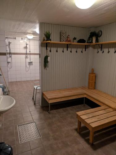a bathroom with a shower and a bench and a sink at Hotell Nederhögen Vildmarkscenter in Rätan