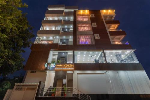 a tall building with many windows at night at Treebo Adithi Comforts Inn And Suites in Mysore
