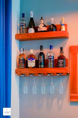 a row of bottles and glasses on a shelf at Lakshani Villa in Polonnaruwa