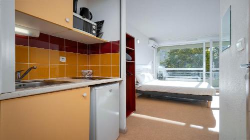 a kitchen with a sink and a bed in a room at Le St Clair N208 ST2 in Agde