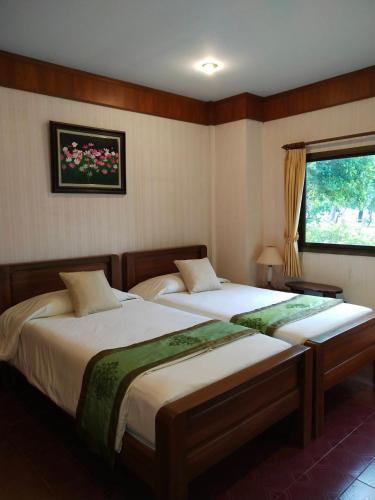 a bedroom with two beds and a window at Samroiyod Holiday Resort in Sam Roi Yot