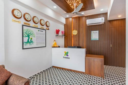 a waiting room with clocks on the wall at Treebo Adithi Comforts Inn And Suites in Mysore