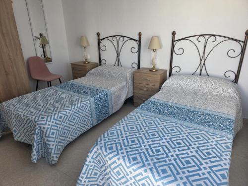 a bedroom with two beds and a chair at Casa Alvarez Tazacorte in Tazacorte