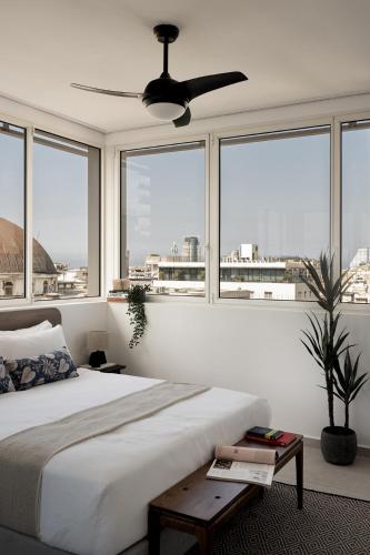 a bedroom with a large bed with a ceiling fan at Mr Rothschild By TLV2GO in Tel Aviv