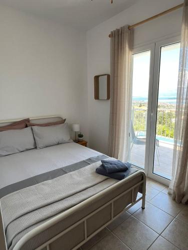 a bedroom with a bed and a large window at Villa Christina Nidri in Nydri