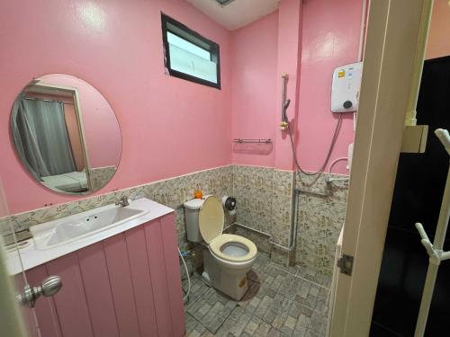 a pink bathroom with a toilet and a sink at OYO 75539 Phanthida Resort and Cafe in Hua Hin