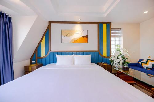 a bedroom with a large white bed and blue curtains at Sky Charm Hanoi Hotel and Spa in Hanoi