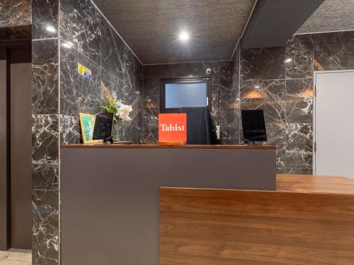 a cashier counter in a lobby with black marble walls at Hotel Story Namba by Tabist in Osaka