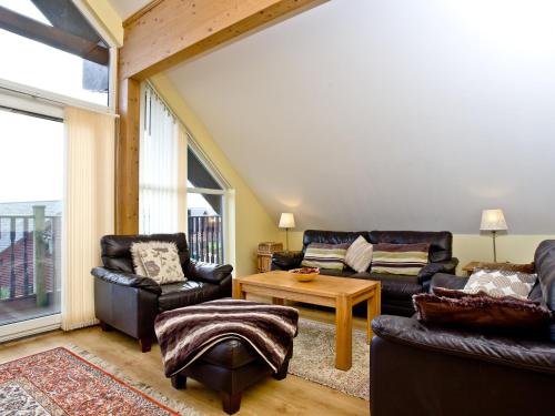 a living room with two leather chairs and a table at Beech Lodge - Retallack Resort in Saint Columb Major