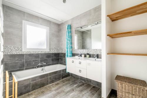 a bathroom with a tub and a sink and a mirror at Nouveau ! Bulle d'air - Maison avec piscine in Bouaye