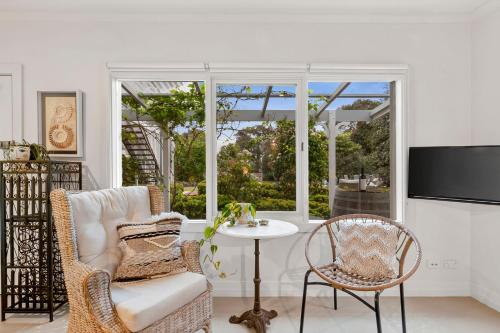 a living room with a table and chairs and a window at Spring Hill Holiday Units - Queenscliff in Queenscliff