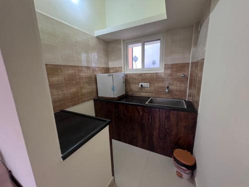 a small kitchen with a sink and a refrigerator at Gold Mountain Wellness Resort in Tiruvannāmalai