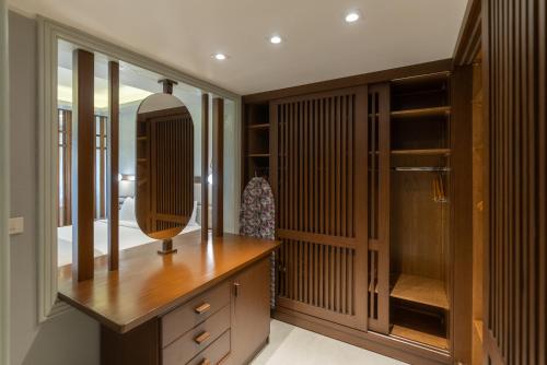 a dressing room with wooden cabinets and a mirror at Sunrise Crystal Bay Resort -Grand Select in Hurghada