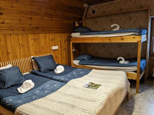 two beds in a room with two bunk beds at Hotell Nederhögen Vildmarkscenter in Rätan