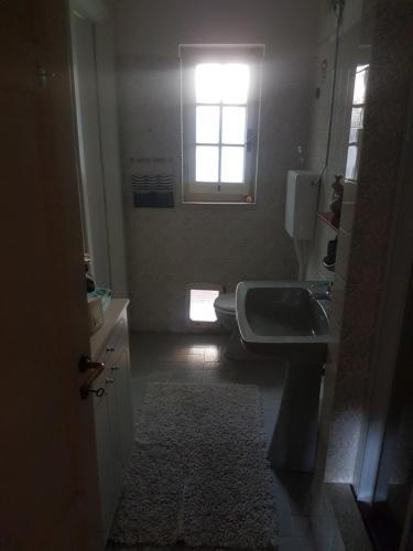a bathroom with a toilet and a sink and a window at La Camera Tra Gli Ulivi Dream Finale in Finale Ligure