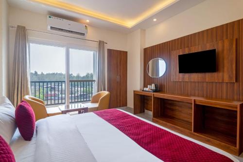 a hotel room with a bed and a television at HOTEL RAH INN - Yog Nagari Rishikesh Railway Station in Rishīkesh