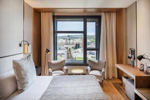 a hotel room with a bed and a window at Catalonia Barcelona Plaza in Barcelona