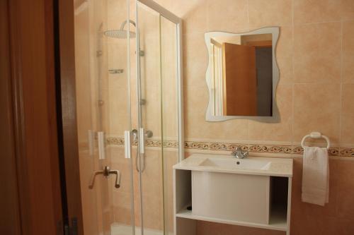 a bathroom with a sink and a shower with a mirror at Delfines II Solo Familias Serviplaya in Playa de Xeraco
