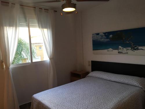 a bedroom with a bed and a window at Xaloc Solo Familias Serviplaya in Playa de Xeraco