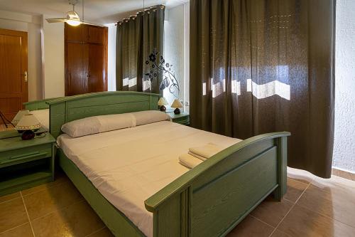 a bedroom with a green bed and a window at Maryvent Solo Familias Serviplaya in Playa de Xeraco