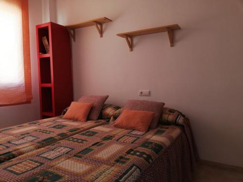 a bedroom with a bed with orange pillows on it at Mediterránea Solo Familias Serviplaya in Playa de Xeraco