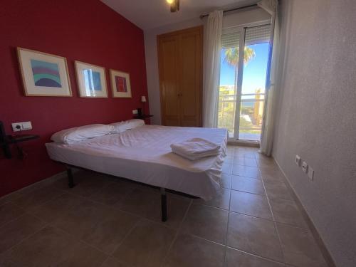 a bedroom with a bed in a red wall at Solmar II Solo Familias Serviplaya in Playa de Xeraco