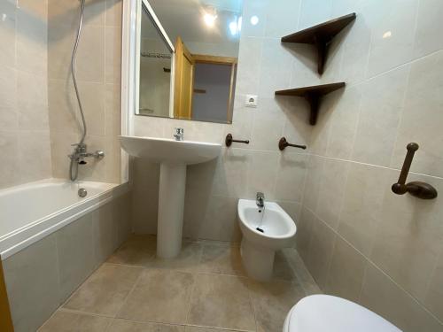 a bathroom with a sink and a toilet and a mirror at Solmar II Solo Familias Serviplaya in Playa de Xeraco