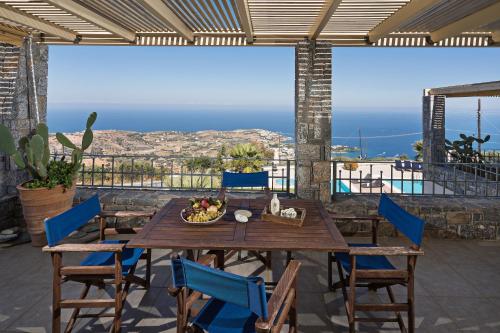 a table and chairs on a patio with a view of the ocean at Sea Views at villa Anemomylos with Heated Pool, Ping Pong and Tennis in Agia Pelagia