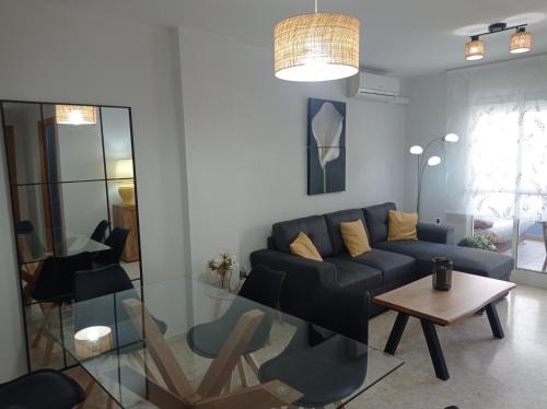 a living room with a couch and a table at Palmeras III Solo Familias Serviplaya!!! in Gandía