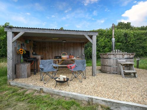 a patio with chairs and a grill and a barrel at The Sheep Pod - Uk50074 in Welshpool