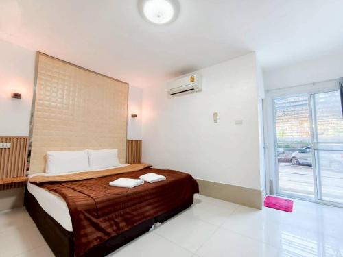 a bedroom with a bed with two towels on it at Veerakit Grand Hotel Udon Thani in Udon Thani