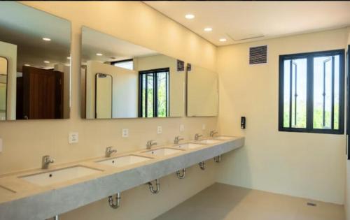 a row of sinks in a bathroom with mirrors at Lay Day Hostel Uluwatu in Uluwatu