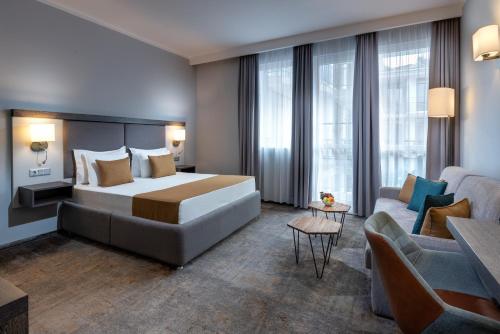 a hotel room with a bed and a couch at Best Western PLUS Premium Inn in Sunny Beach